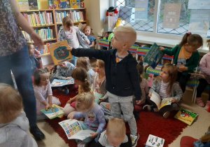Chłopiec oddaje pani bibliotekarce obejrzaną książeczkę